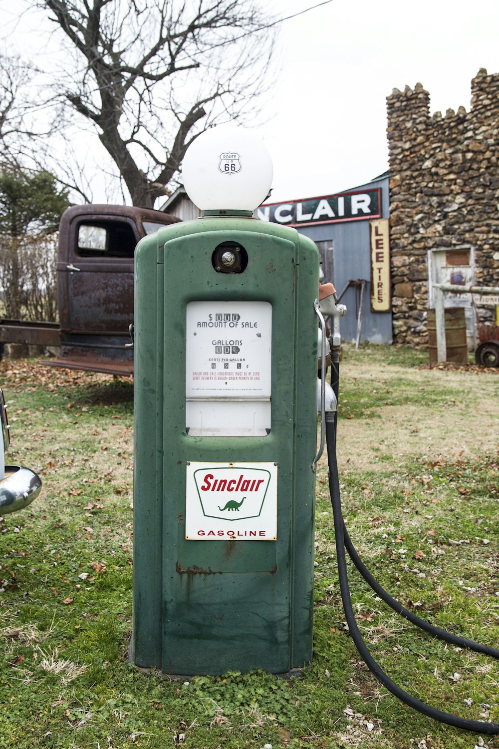 an old green gas pump sitting in the grass