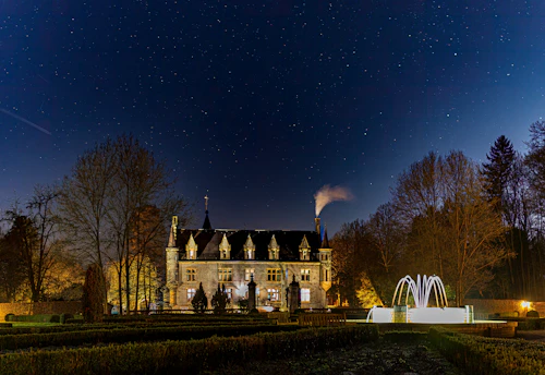 An elegant castle courtyard bathed in soft evening light, set for a luxurious wedding event.