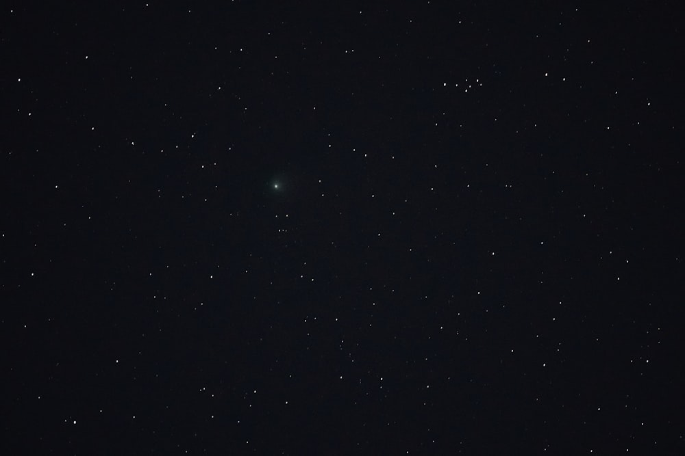 a night sky with stars and a bright green object