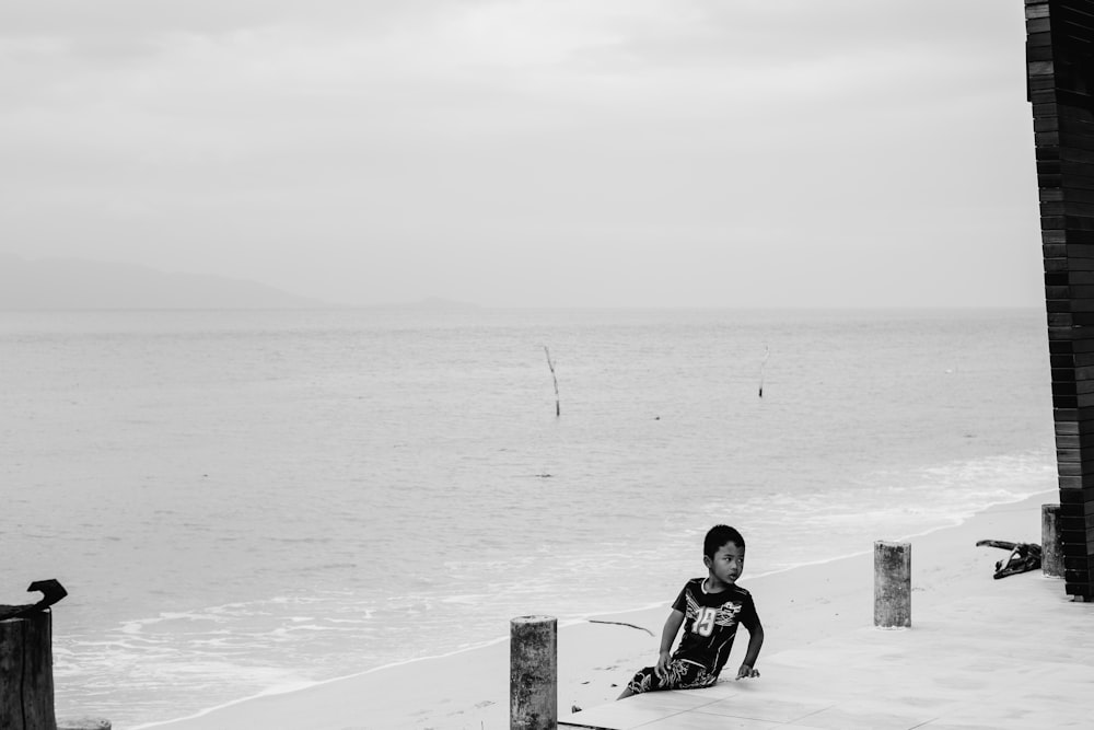 um homem sentado na praia ao lado do oceano