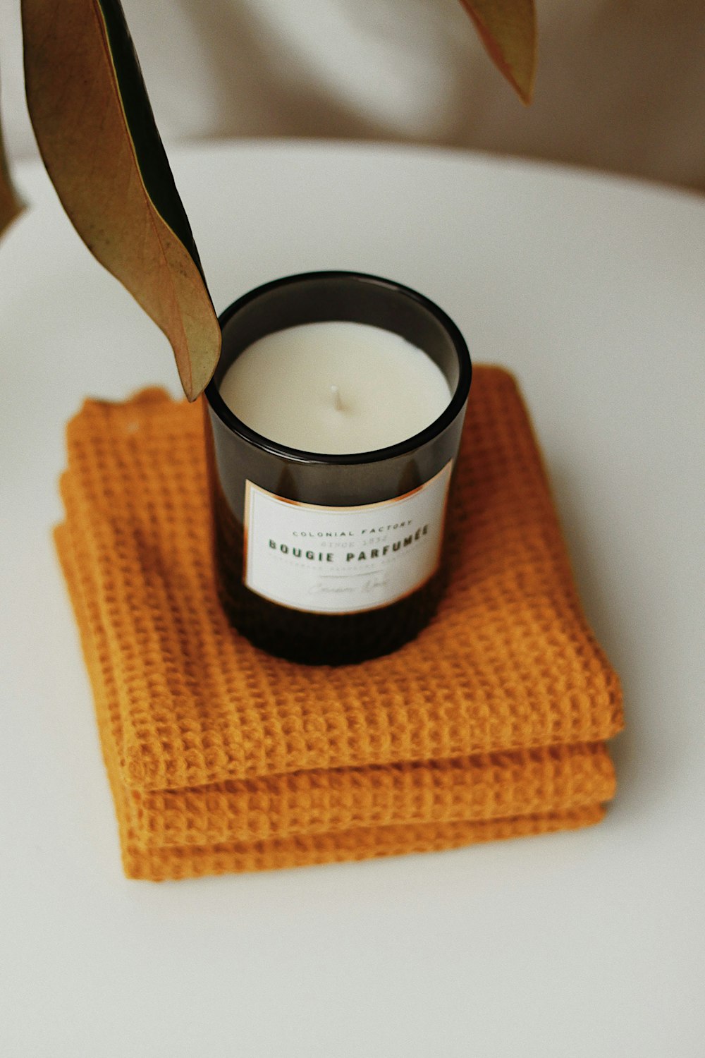 a candle sitting on top of a napkin on top of a table