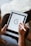 A close-up of a designer's hands working on a digital tablet.