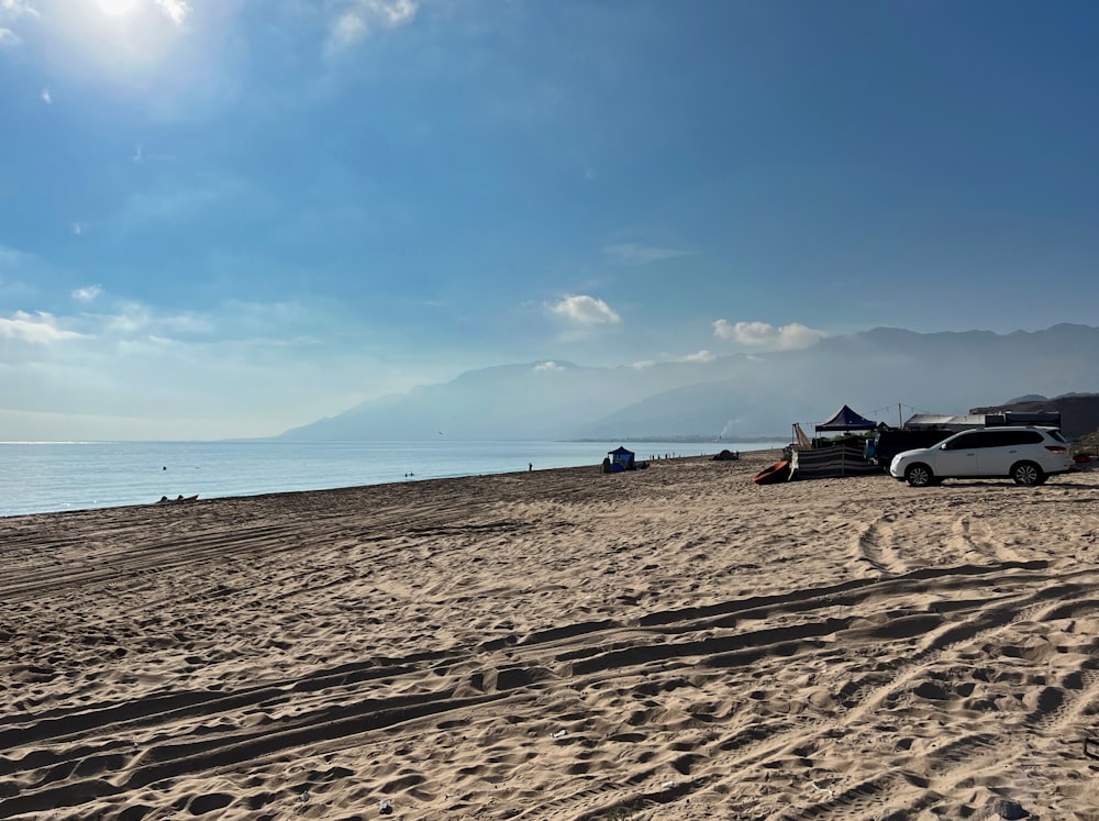 a truck parked on a beach next to the ocean