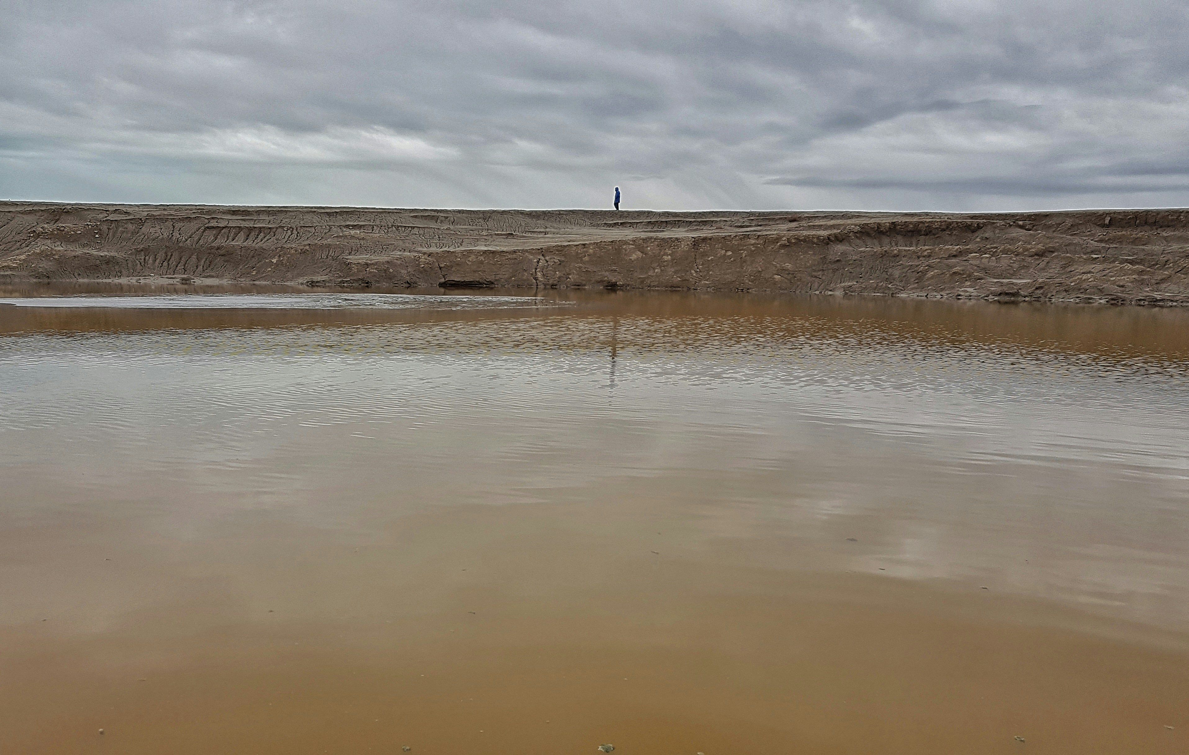 a body of water sitting on top of a sandy beach