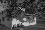 An outdoor study session under the shade of a large tree at Shalom Bible College.