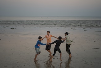 a group of people standing on top of a beach