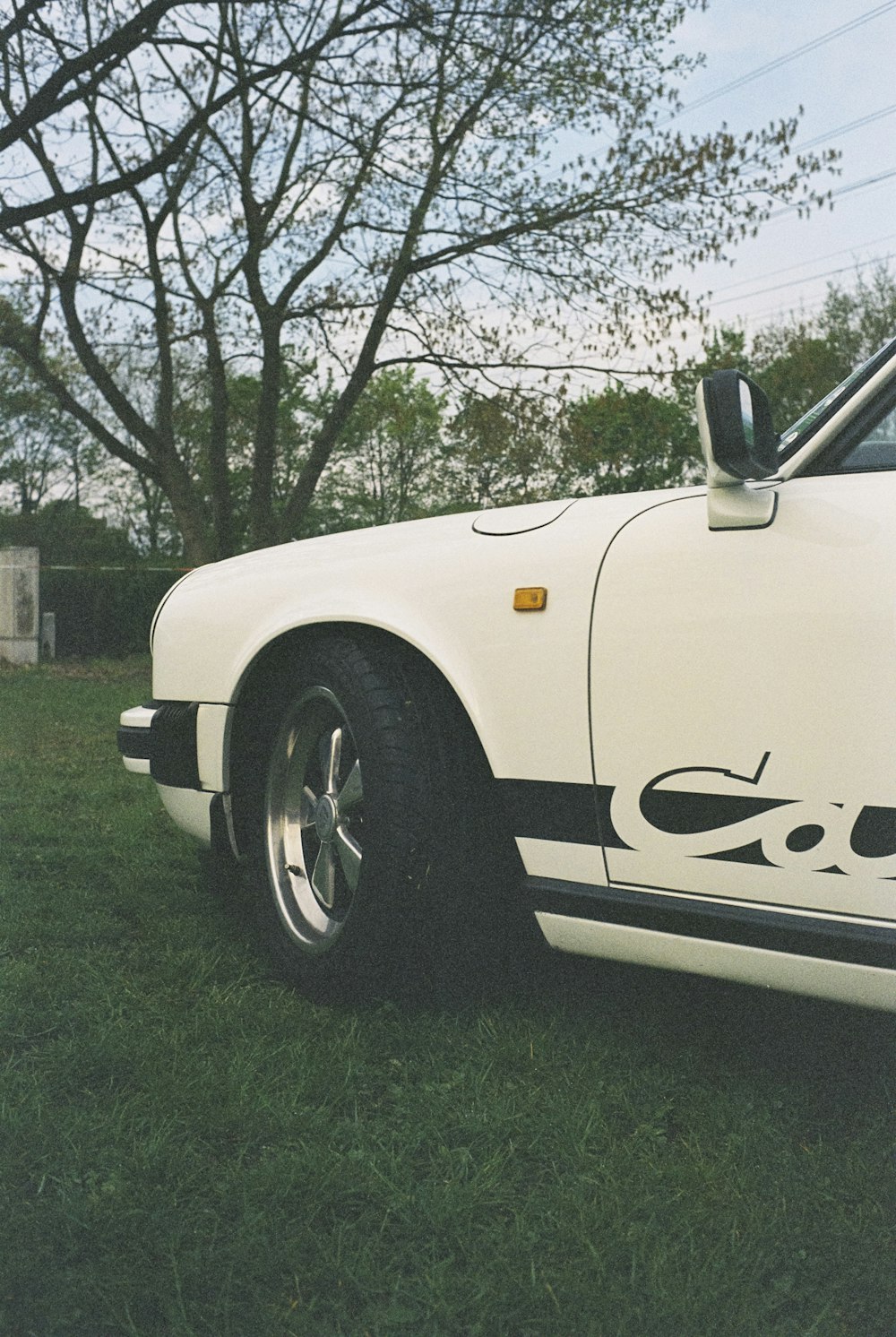 a white sports car parked in the grass