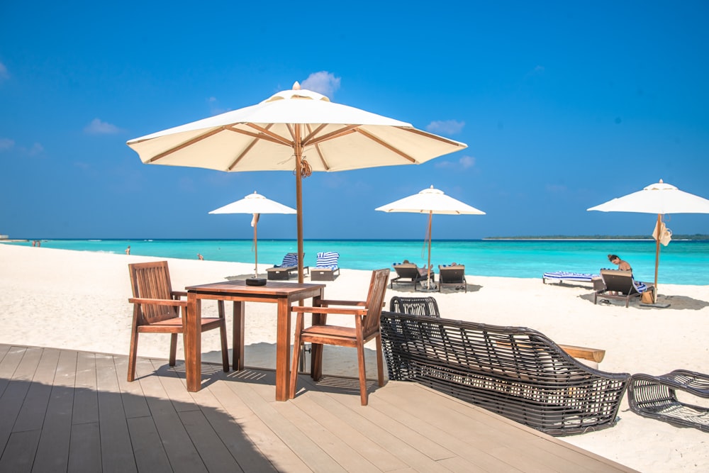 a table and chairs on a beach with umbrellas