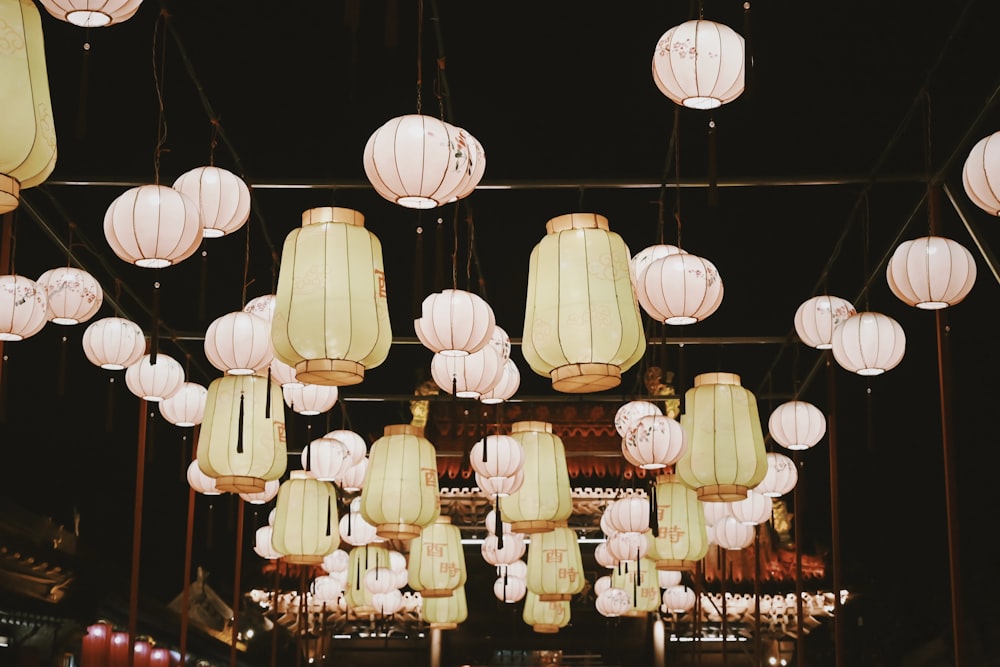 a room filled with lots of white paper lanterns