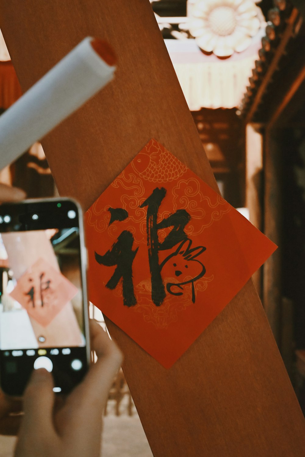 a person taking a picture of an oriental calligraphy