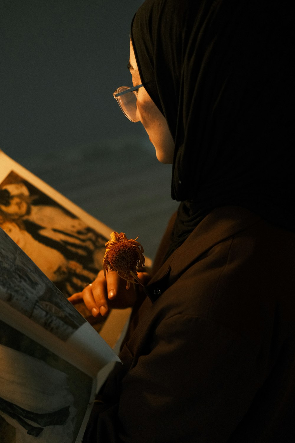 a woman in a hijab is reading a book