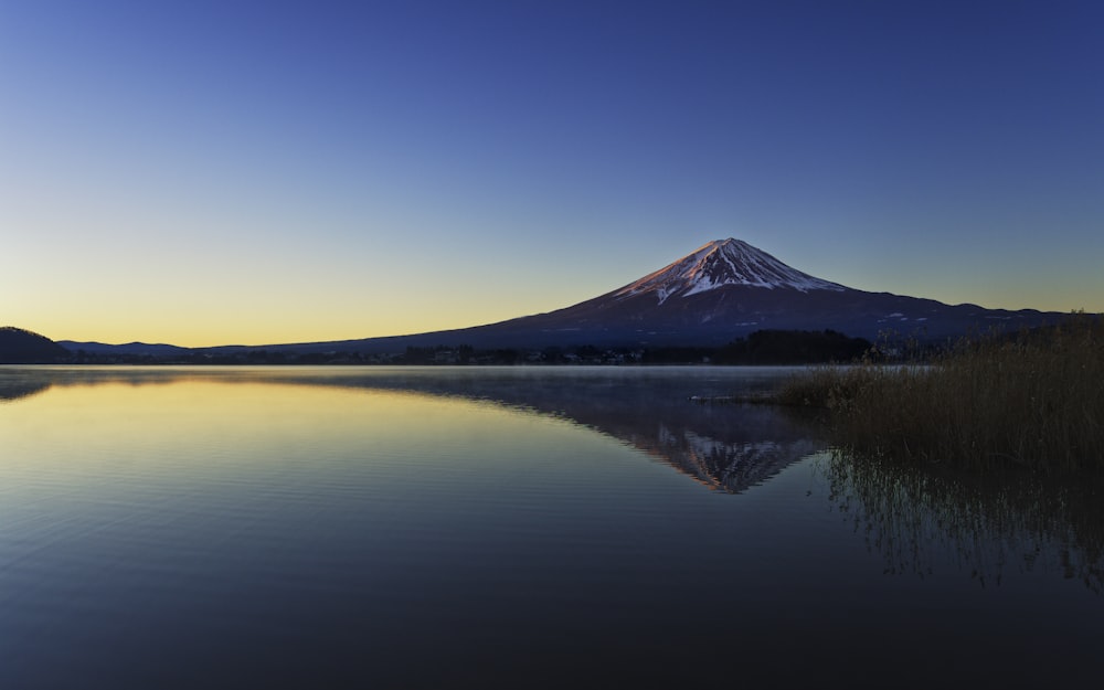 a mountain is reflected in the still water of a lake