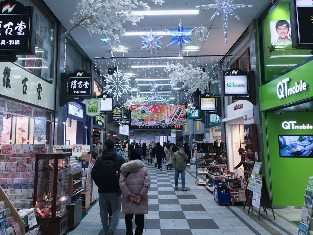 a group of people walking down a shopping mall