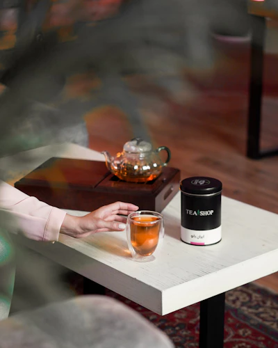 a woman sitting at a table with a glass of tea