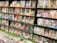 A bookstore shelf filled with various volumes of manga, displaying colorful covers featuring anime-style illustrations. The shelves are densely packed, and multiple rows showcase an array of genres. The titles and artwork reflect a vibrant and diverse selection typical in Japanese manga stores.