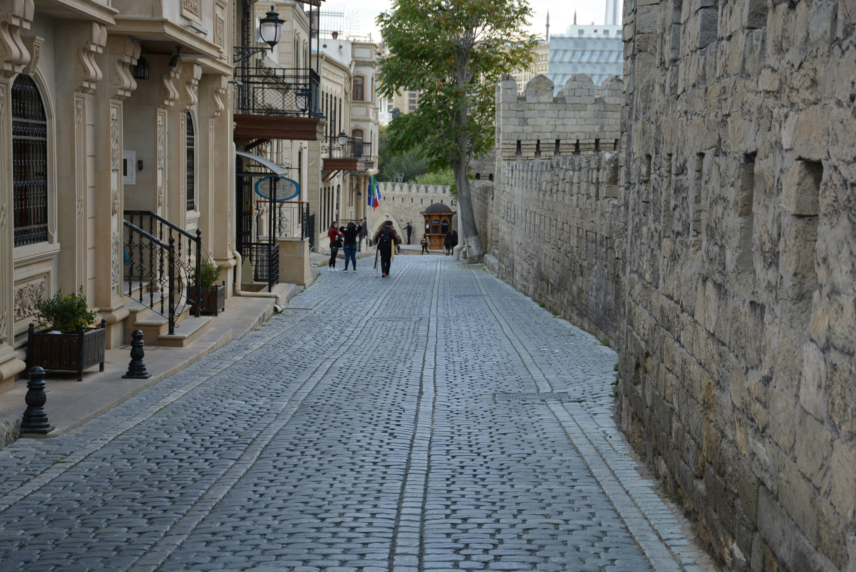 a cobblestone street with people walking down it