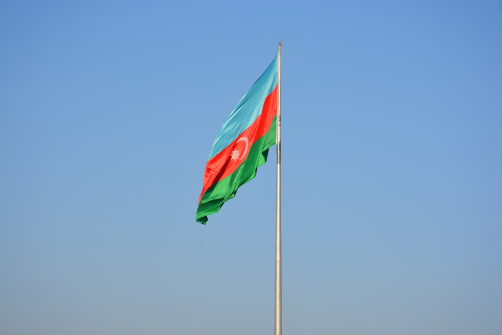 Una bandera ondeando en el viento en la parte superior de un asta de bandera