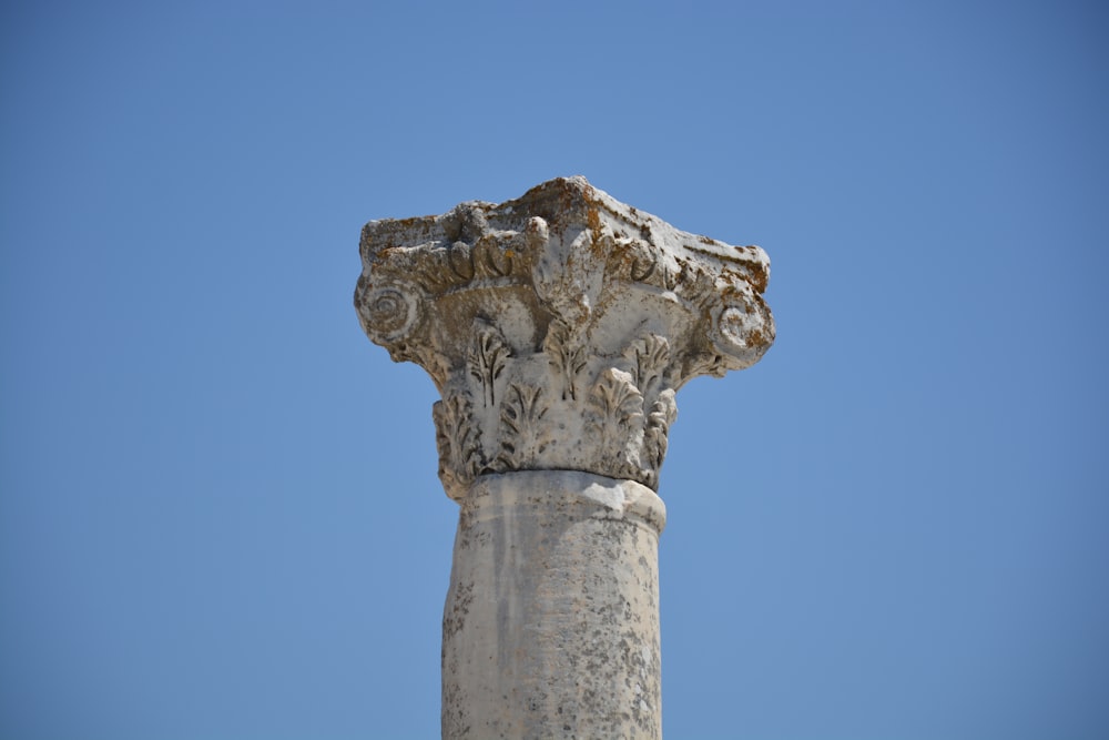 Un primo piano di una colonna di pietra con uno sfondo del cielo
