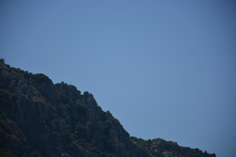 a plane flying in the sky over a mountain