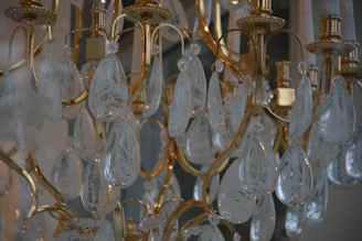 Close-up of a shimmering gold chandelier casting soft glows over a sleek modern banquet table.