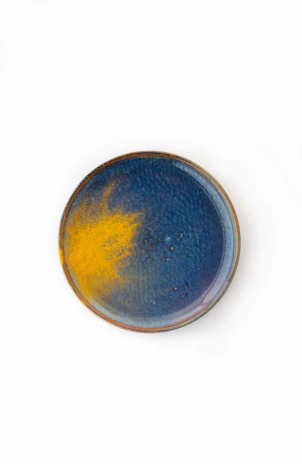Close-up of a vibrant stoneware plate with subtle textures and a glossy finish.
