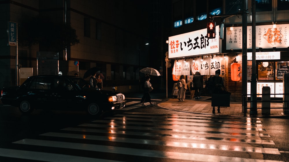 a group of people standing outside of a building at night