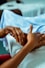 a person holding another person's hand in a hospital bed