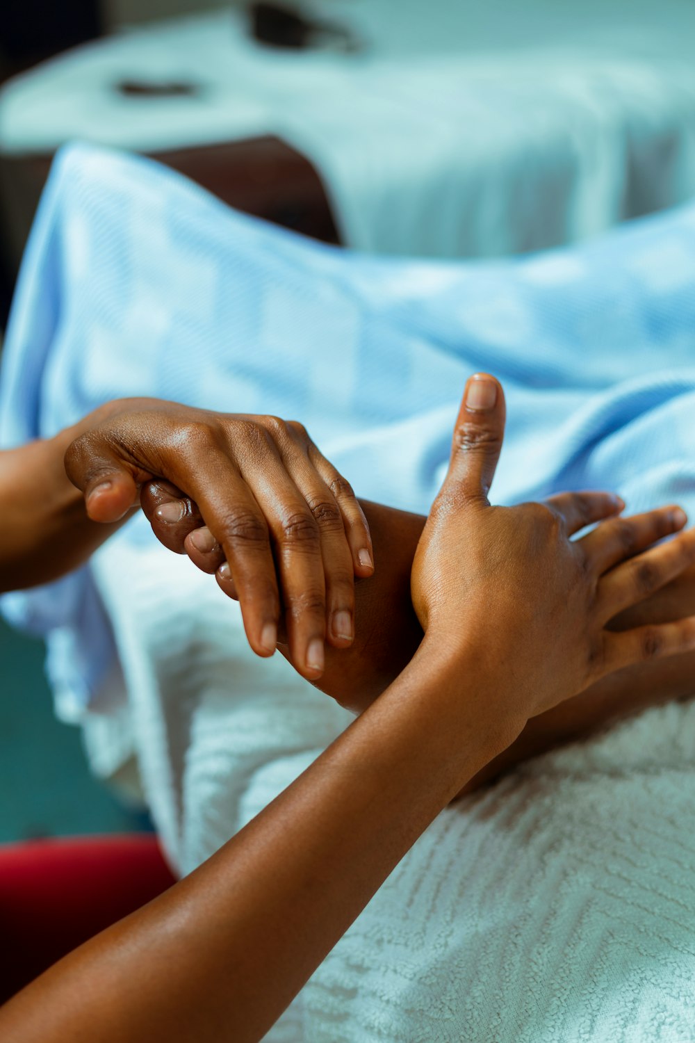 a person holding another person's hand in a hospital bed