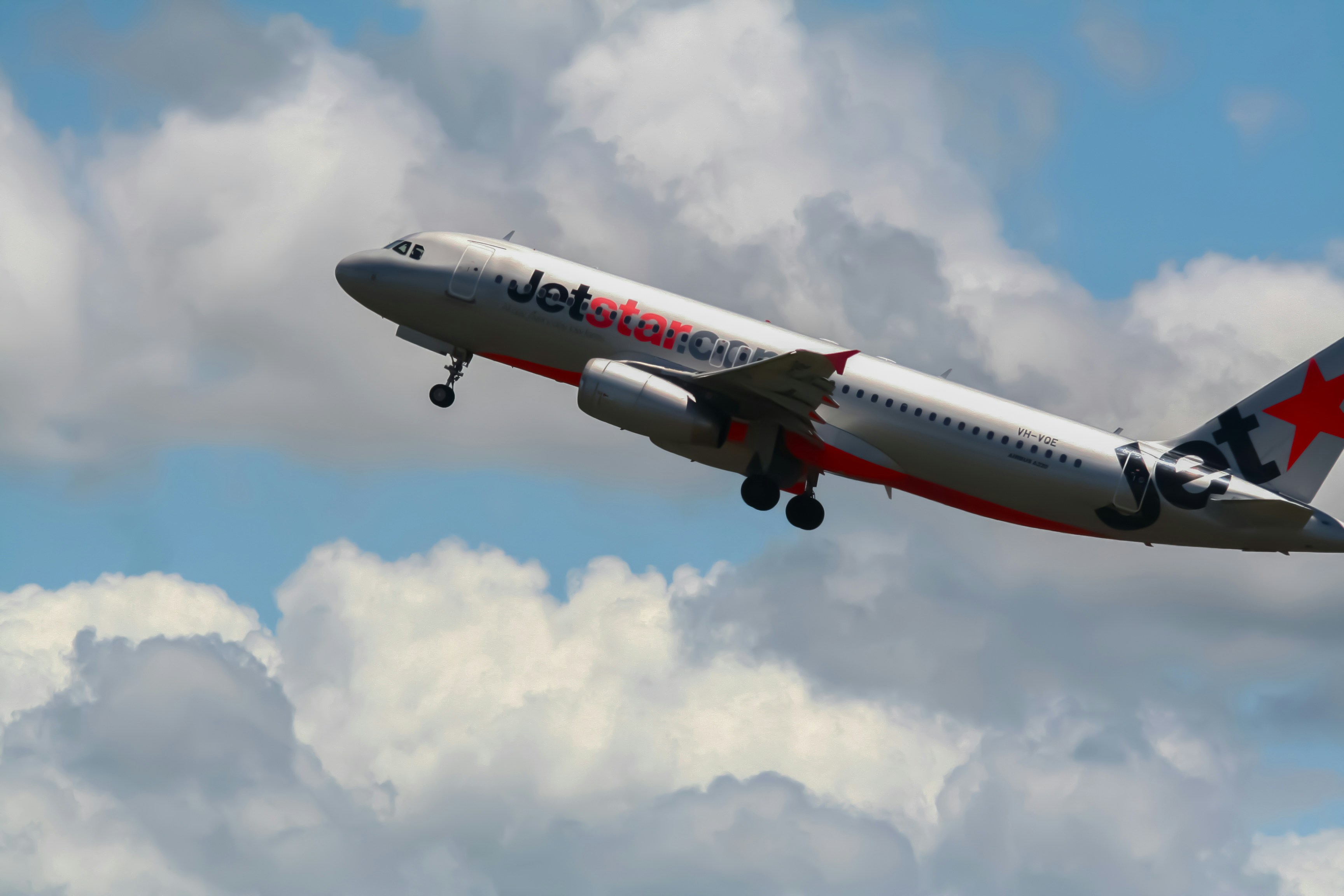 a large jetliner flying through a cloudy blue sky