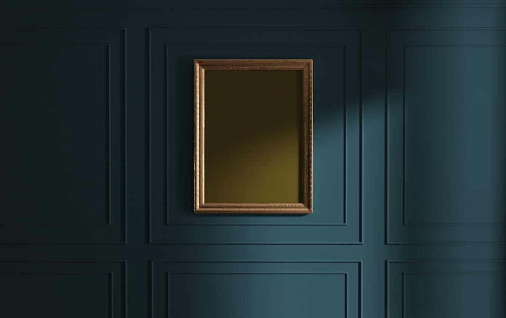 a blue room with a gold framed mirror on the wall