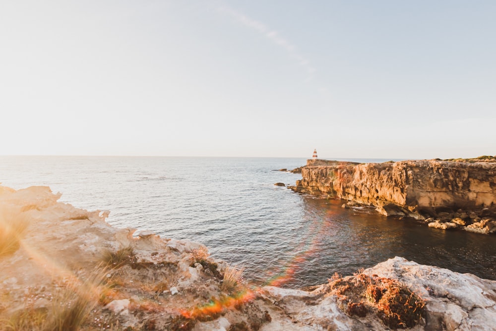 a person standing on a cliff overlooking the ocean