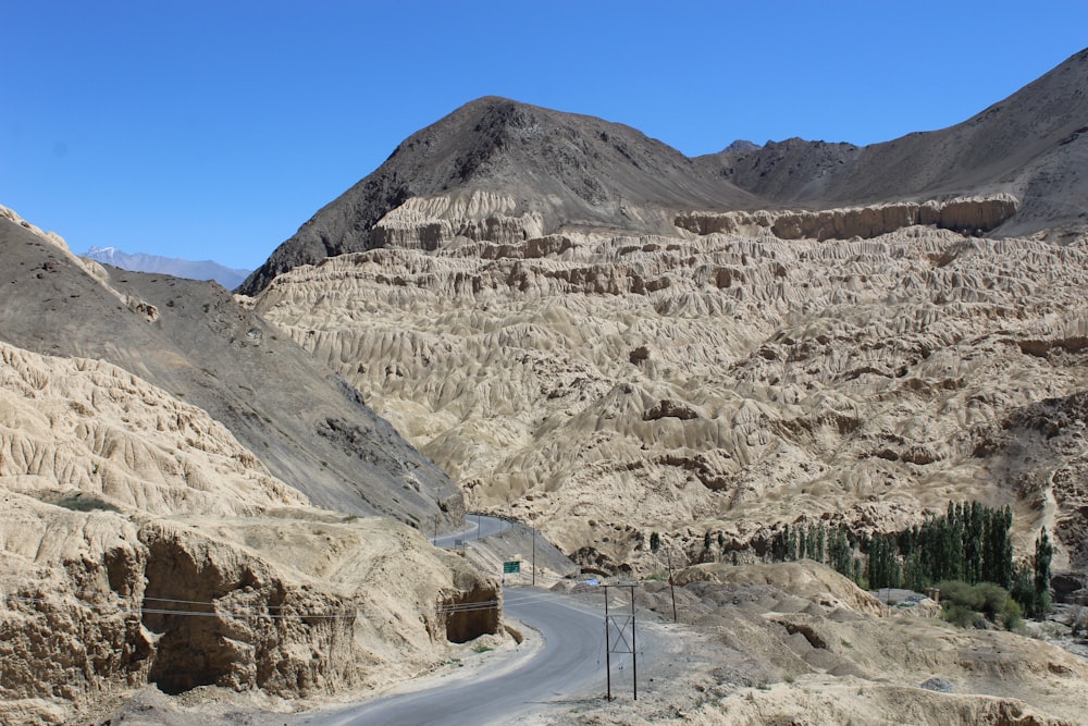 a road in the middle of a desert with mountains in the background