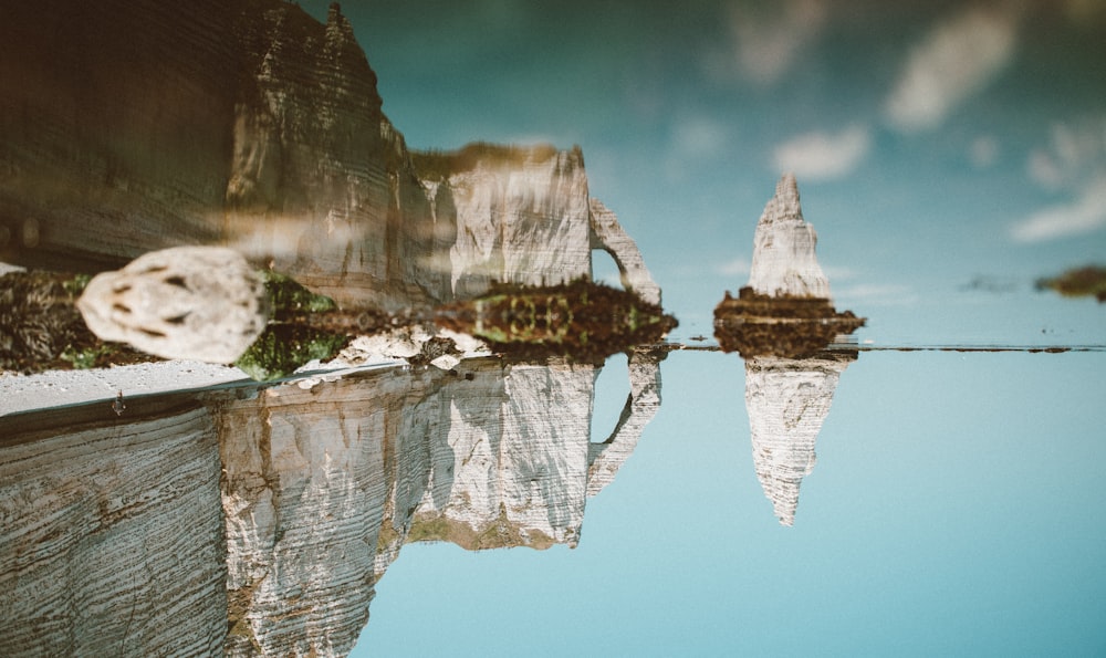 a reflection of a mountain and a body of water