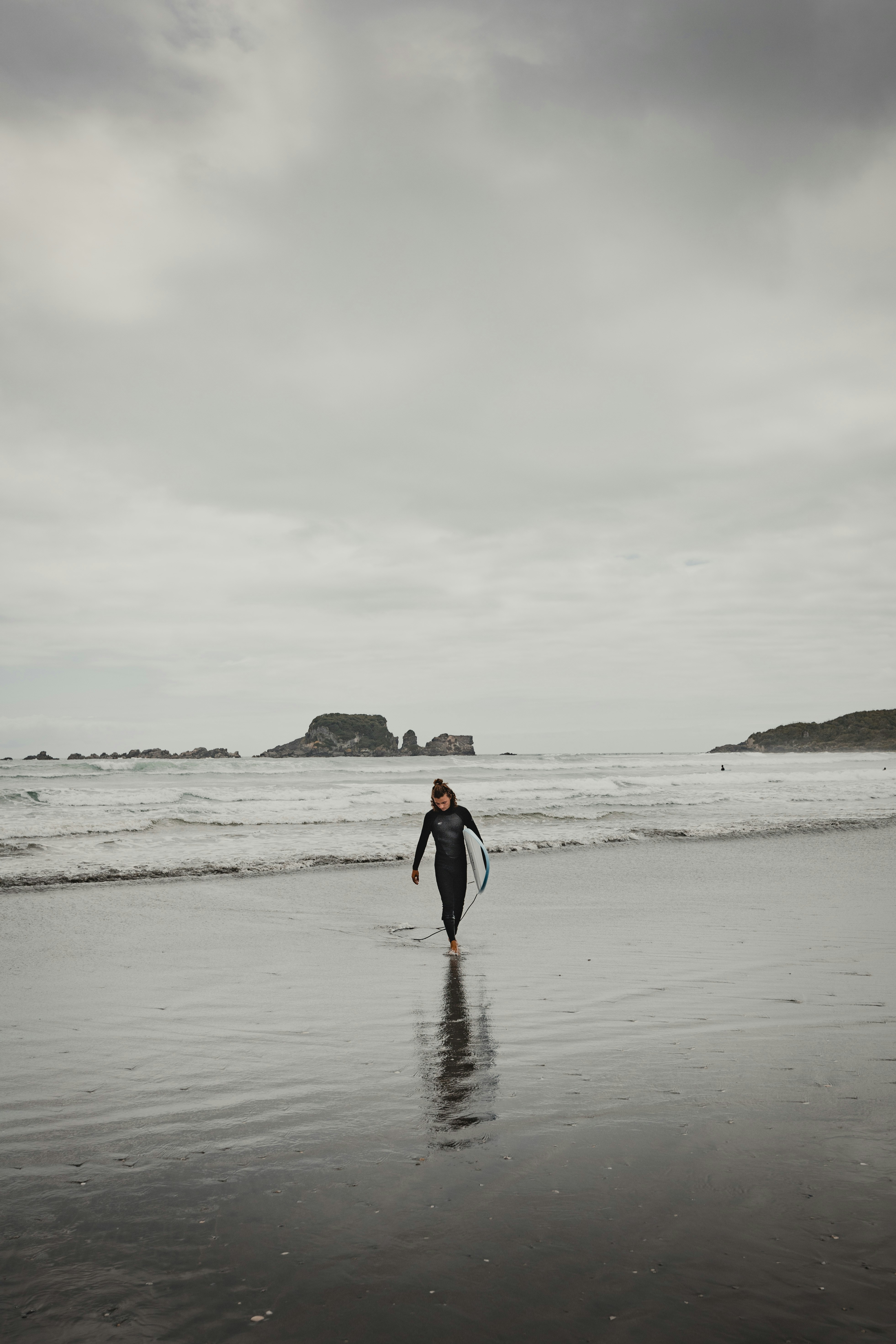 a person walking on a beach with a surfboard