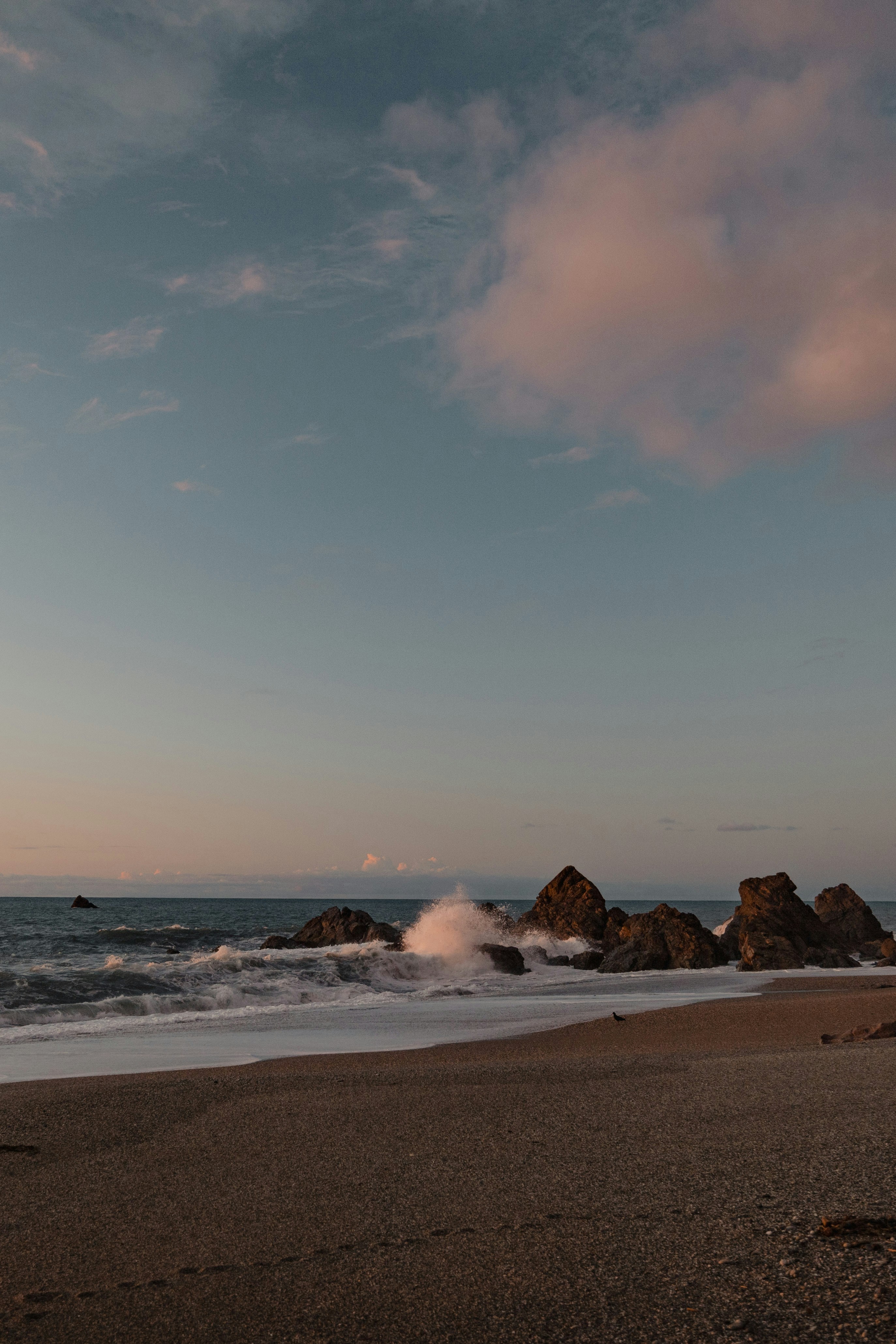 a sandy beach with waves crashing into the shore