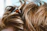 Close-up of a woman with glossy, voluminous hair extensions styled in soft waves.