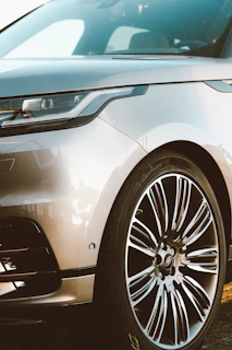 Close-up of a sleek car with a custom front lip and aggressive stance under natural light.
