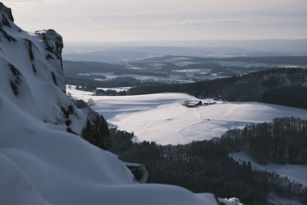 a snow covered mountain with a view of a valley