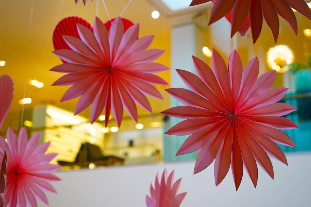 a group of red paper flowers hanging from a ceiling