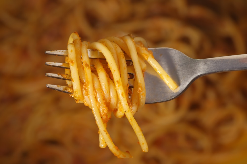 a fork full of spaghetti being held by a fork