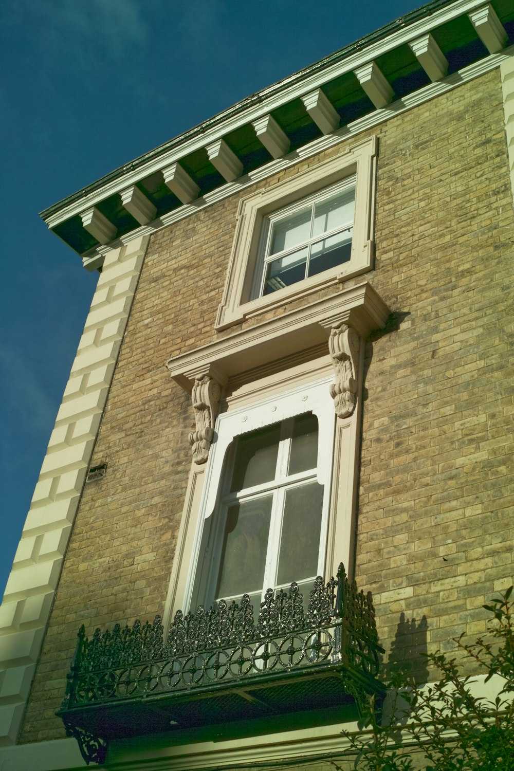 a tall brick building with a window and a balcony