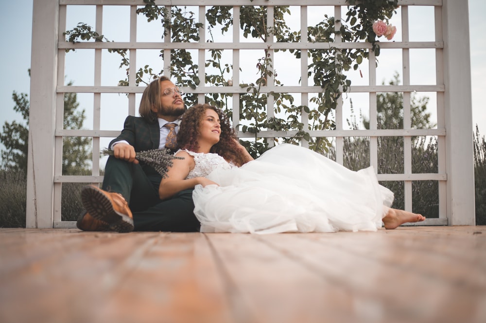 a bride and groom laying on the ground