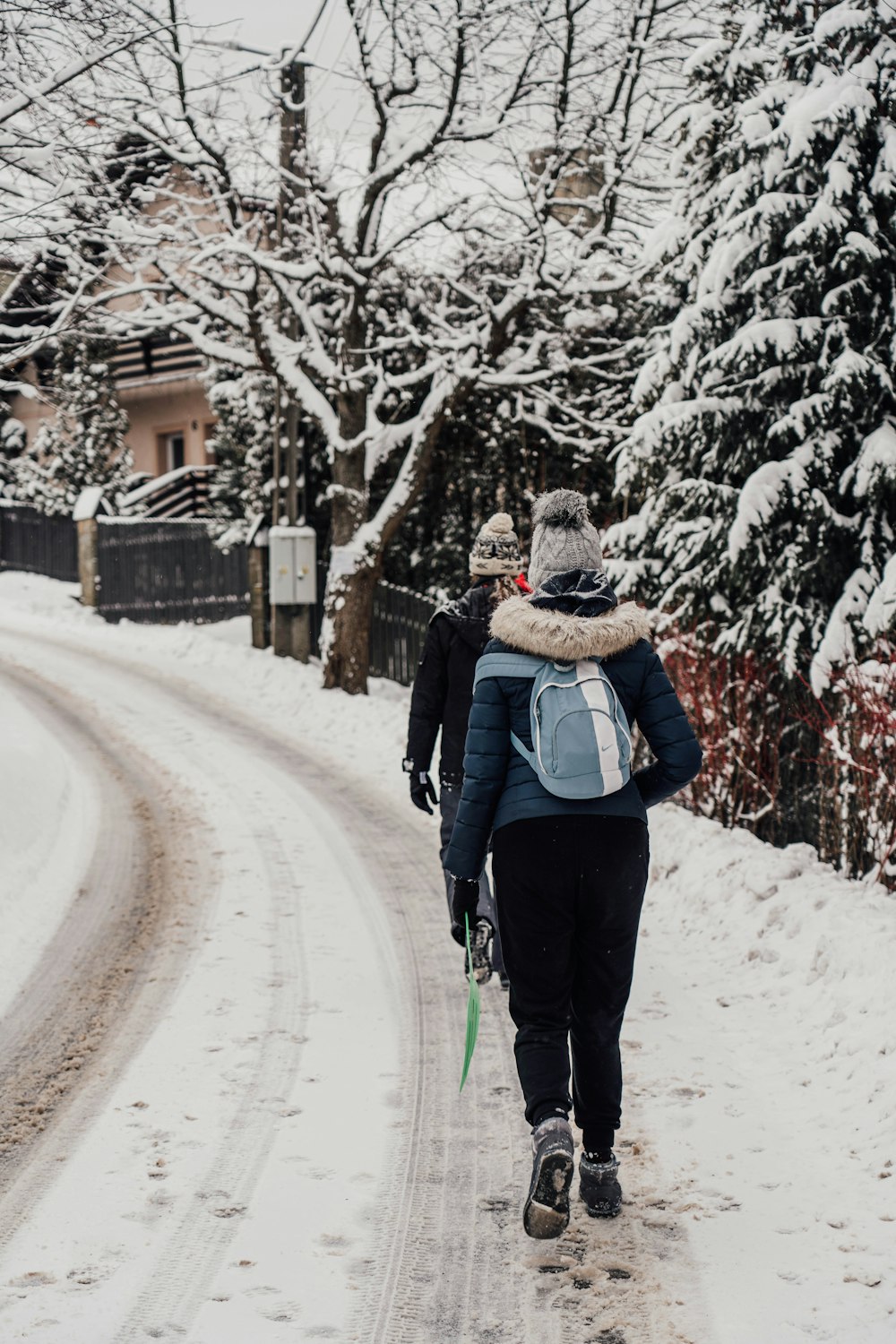 a woman walking down a snow covered road