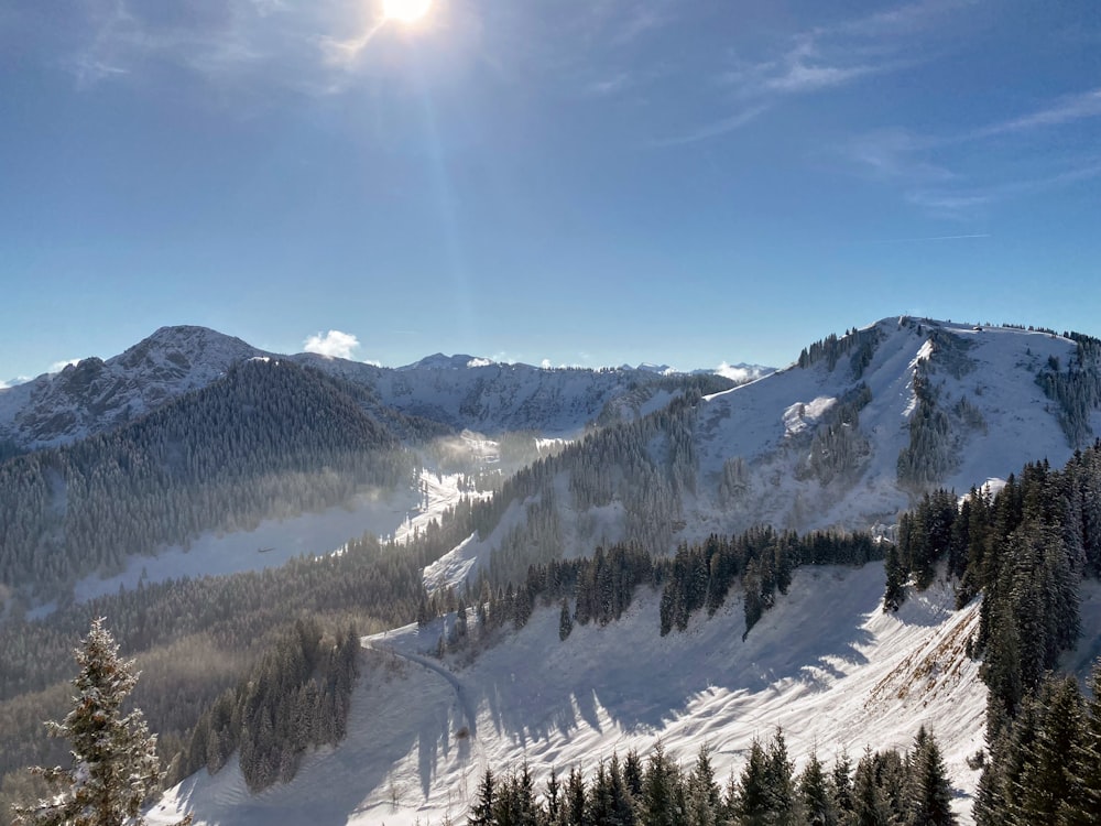 the sun shines brightly on a snowy mountain