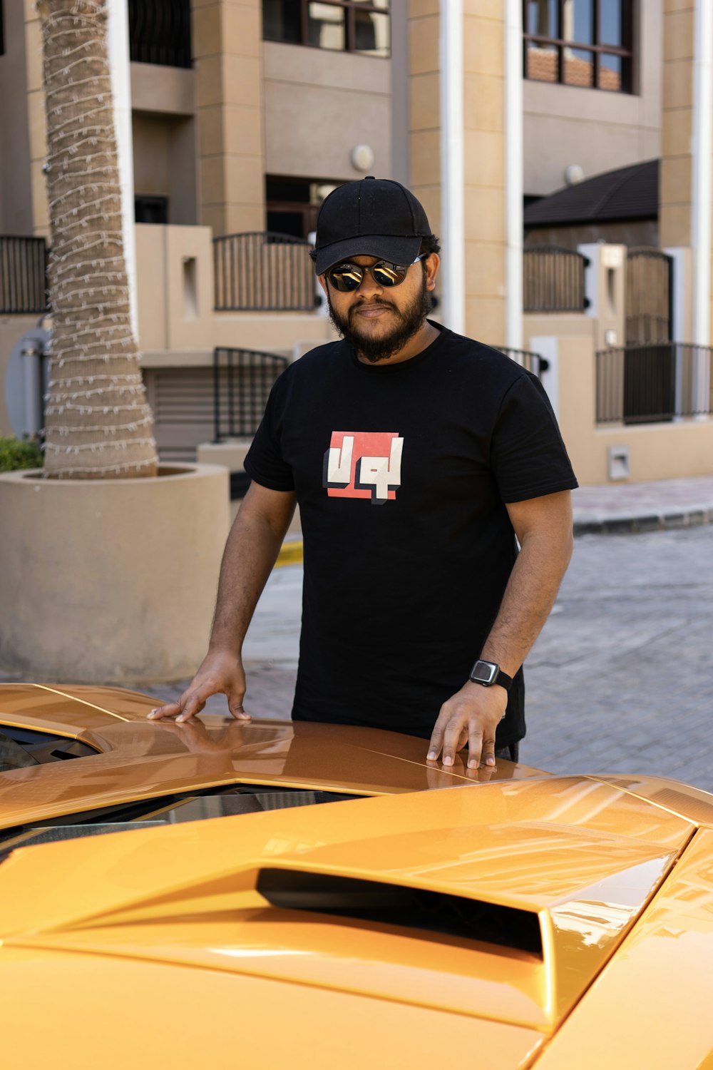 a man standing next to a yellow sports car