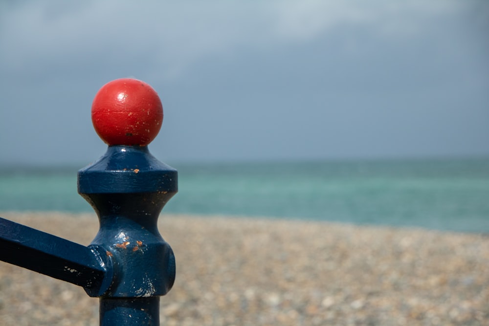 a red ball sitting on top of a blue railing