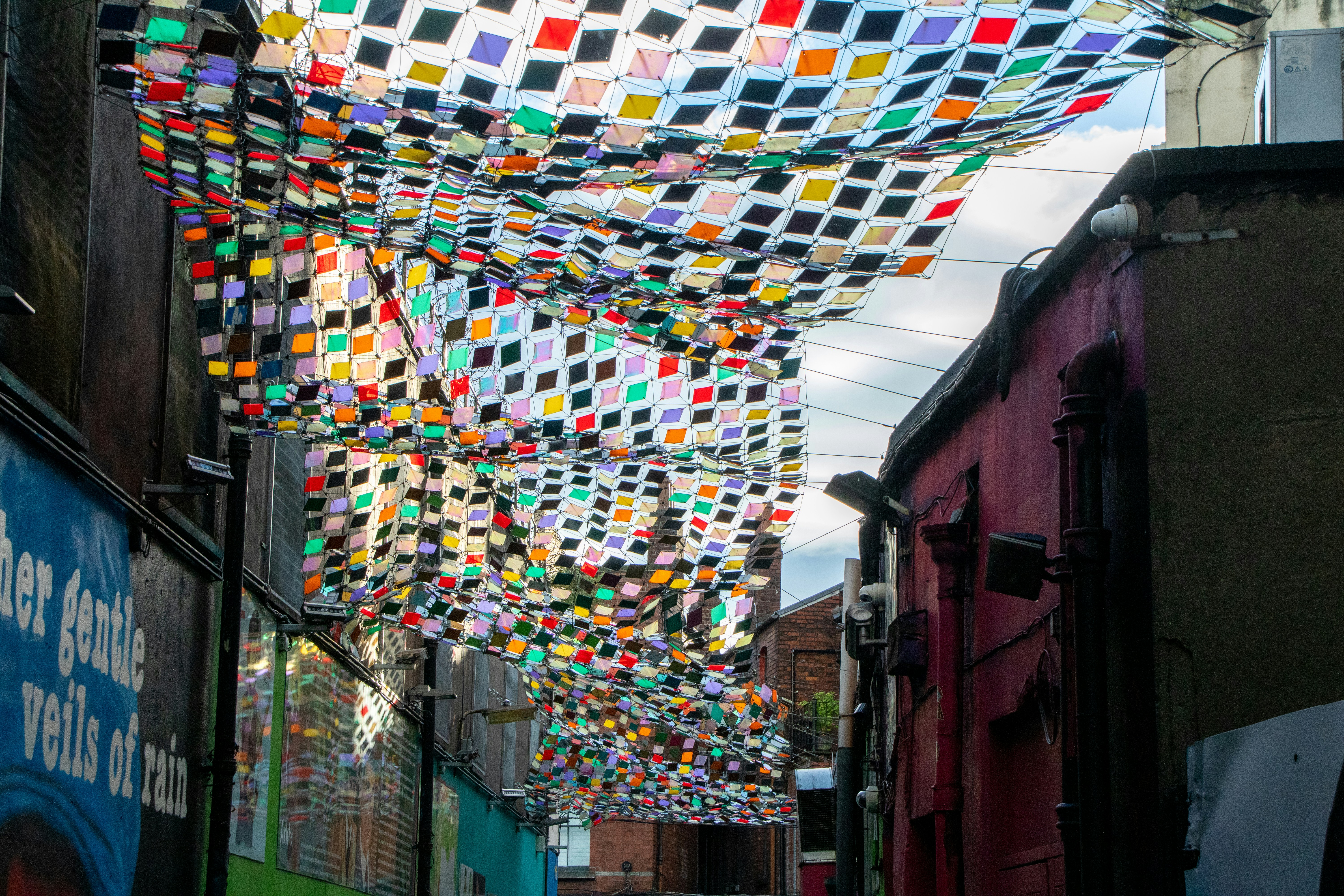 a street filled with lots of colorful flags hanging from the side of buildings