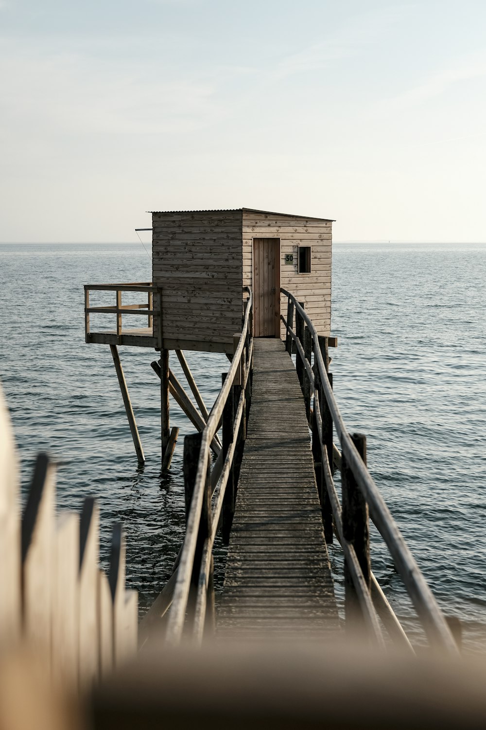 a wooden dock with a small house on it