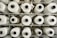 A close-up of soft tissue paper rolls stacked neatly on a wooden shelf.