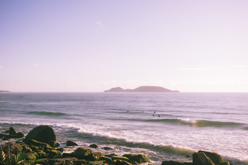 a group of people riding surfboards on top of a wave